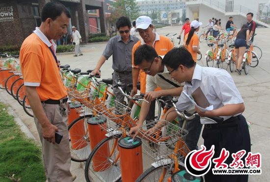采訪團(tuán)記者做好準(zhǔn)備體驗(yàn)公共自行車(chē)。 記者 郭豪 攝。